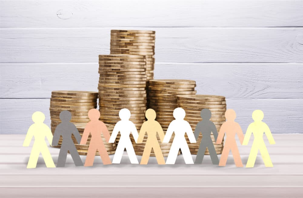 growing stacks of investment money with community of paper mache people in front